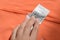 Woman holding clothing label on coral garment, closeup