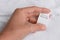 Woman holding clothing label on white garment, closeup