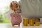 Woman holding a coin in a glass jar Close-up of young woman putting gold coins in a jar. Planning, investing and saving ideas.