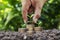 Woman holding coin with tree on coin to save money and blurred green nature background