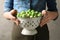 Woman holding colander with fresh Brussels sprouts