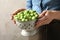 Woman holding colander with fresh Brussels sprouts