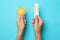 Woman holding condom and birth control pills on blue background. Safe sex