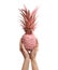 Woman holding coral painted pineapple on white background