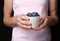 Woman holding crockery with juicy fresh blueberries