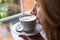 Woman holding a cup of coffee while smelling the aroma of freshly brewed coffee.