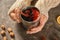 Woman holding cup of delicious mulled wine on grey table, closeup