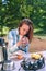 Woman holding cup of hot coffee sitting under