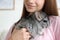 Woman holding cute chinchilla in room