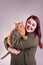 Woman holding cute male orange tabby cat smiling