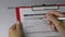 Woman holding an employment application form on top of resume on office table.