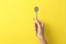 Woman holding empty soda spoon on color background. Space for text