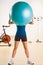 Woman holding exercise ball in health club