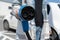 Woman holding fast charging socket CHAdeMO plug for electric vehicles at EV car charging station.