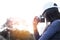 Woman holding film camera taking photograph in the nature sunset