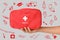 Woman holding first aid kit and different images on grey background, closeup