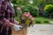 Woman holding flower pot with blooming plant in garden