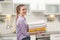 Woman holding folded clean towels in kitchen