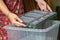 Woman holding frame for making paper sheets from waste paper pulp. Selective focus. Decorative and applied art. Recycling concept,