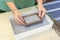 Woman holding frame for making paper sheets from waste paper pulp. Selective focus. Decorative and applied art. Recycling concept,