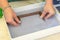 Woman holding frame for making paper sheets from waste paper pulp. Selective focus. Decorative and applied art. Recycling concept,