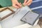 Woman holding frame for making paper sheets from waste paper pulp. Selective focus. Decorative and applied art. Recycling concept,