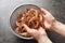 Woman holding fresh shrimps over colander