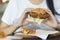 Woman holding fried chicken burger and eatting fast food.