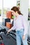 Woman holding fuel pump while refueling automobile with benzine at gas station