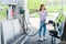 Woman holding fuel pump while refueling car with benzine and talking on smartphone