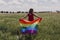 Woman holding the Gay Rainbow Flag on a green meadow outdoors. Happiness, freedom and love concept for same sex couples. LIfestyle