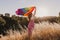 Woman holding the Gay Rainbow Flag at sunset. Happiness, freedom and love concept for same sex couples. LIfestyle outdoors