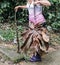 Woman holding giant tropical leaf in forest