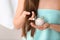 Woman holding glass bowl with hair mask on blurred background, closeup.