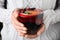 Woman holding glass cup of tasty mulled wine