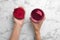 Woman holding glass with fresh beet juice and half