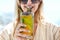 Woman holding a glass of passion fruit cocktail in Santorini background