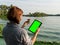 Woman holding green algae sample and tablet with mockup green screen