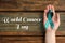 Woman holding green ribbon on background, top view. World Cancer Day