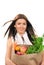 Woman holding grocery bag fresh food items.