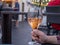 Woman holding half full spritz drink in a glass outdoors at a restaurant