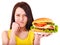 Woman holding hamburger.