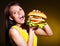 Woman holding hamburger.