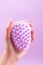 Woman holding in hand scalp massage and cleansing shampoo brush on purple background, closeup