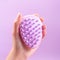 Woman holding in hand scalp massage and cleansing shampoo brush on purple background, closeup
