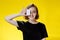 Woman holding in hands demonstrating bank card novelty on yellow background