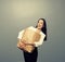 Woman holding heavy paper bag over dark