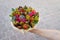 Woman holding in her hand the tasty gift in the form of a bouquet of exotic fruits