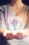 Woman holding hologram with lighbulb icon