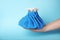 Woman holding ice pack against blue background